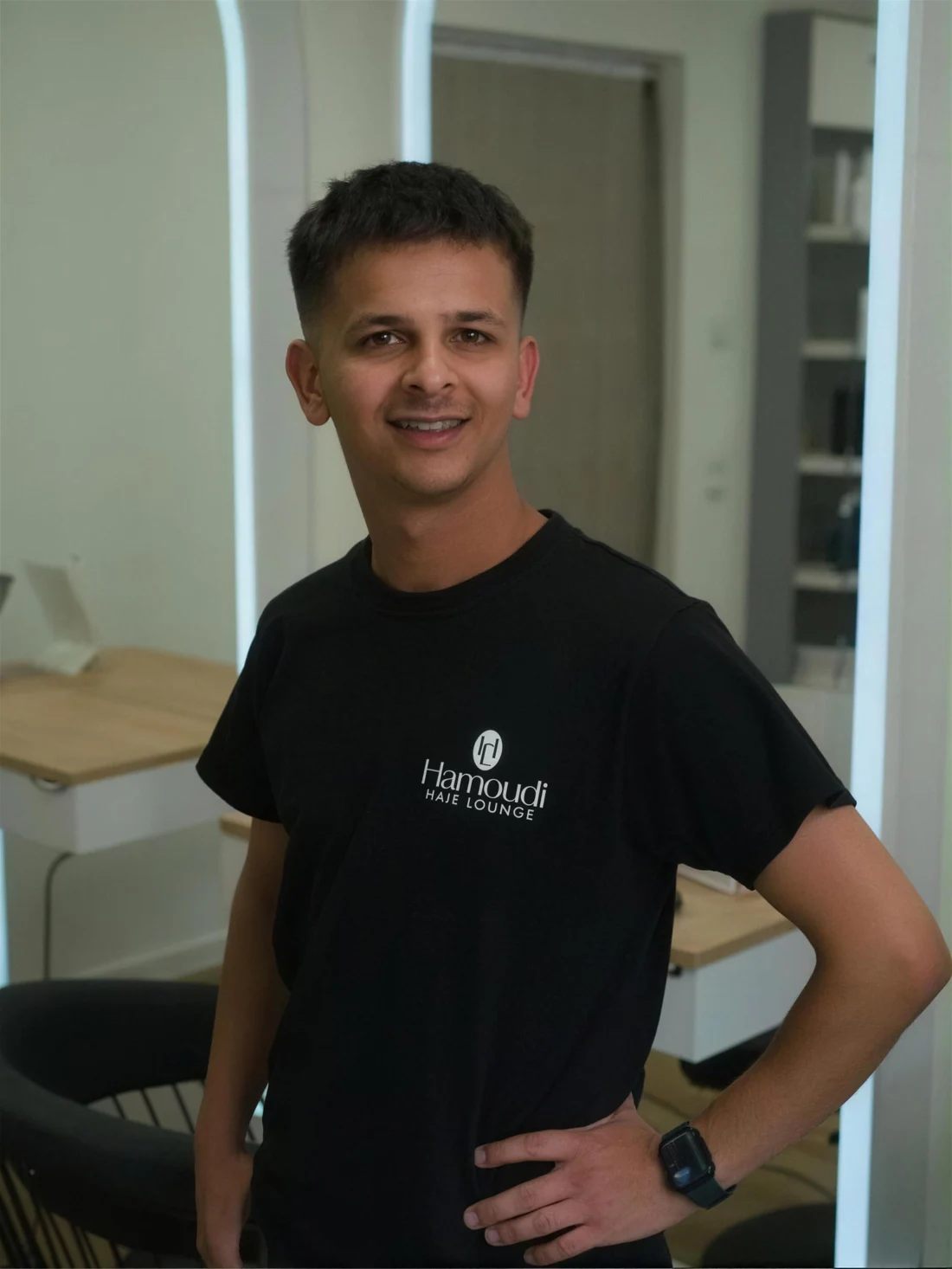 Ahmed — der Auszubildende der Hamoudi Hair Lounge, Blick in die Kamera.