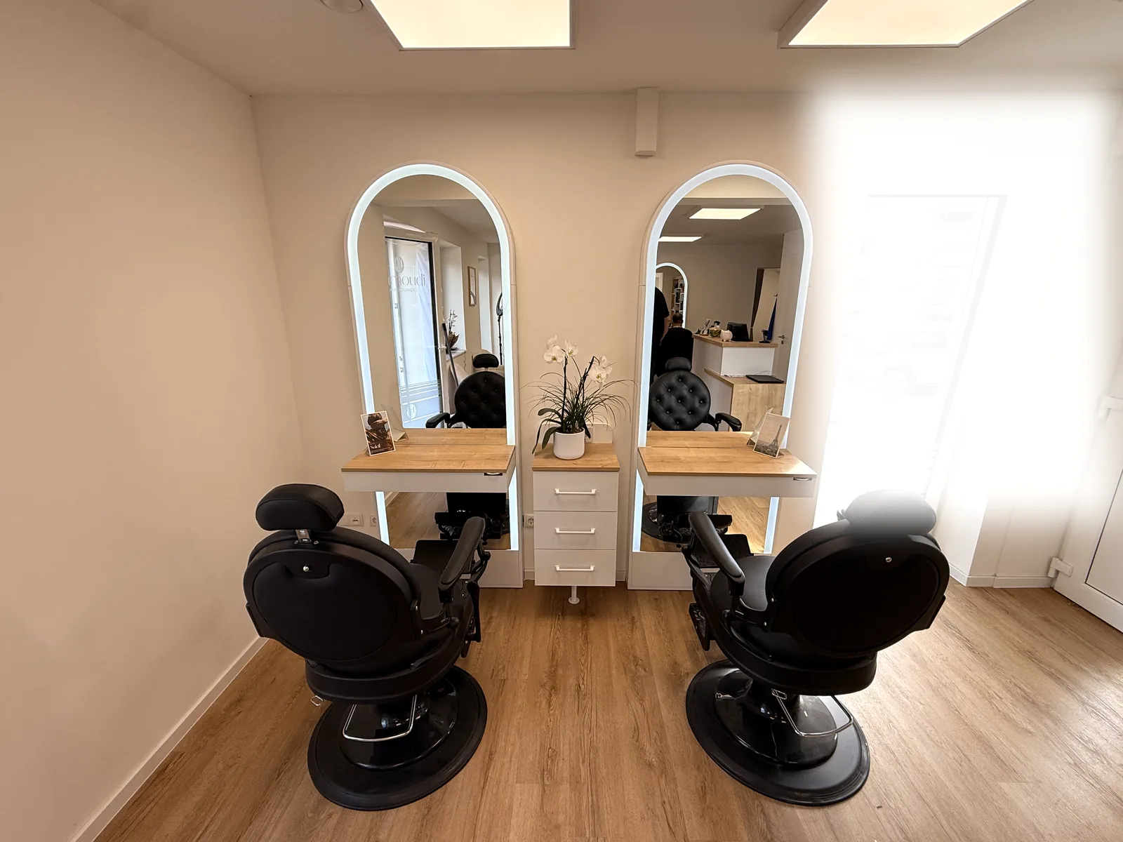 Herrenbereich mit zwei Vintage-Barber-Stühlen.